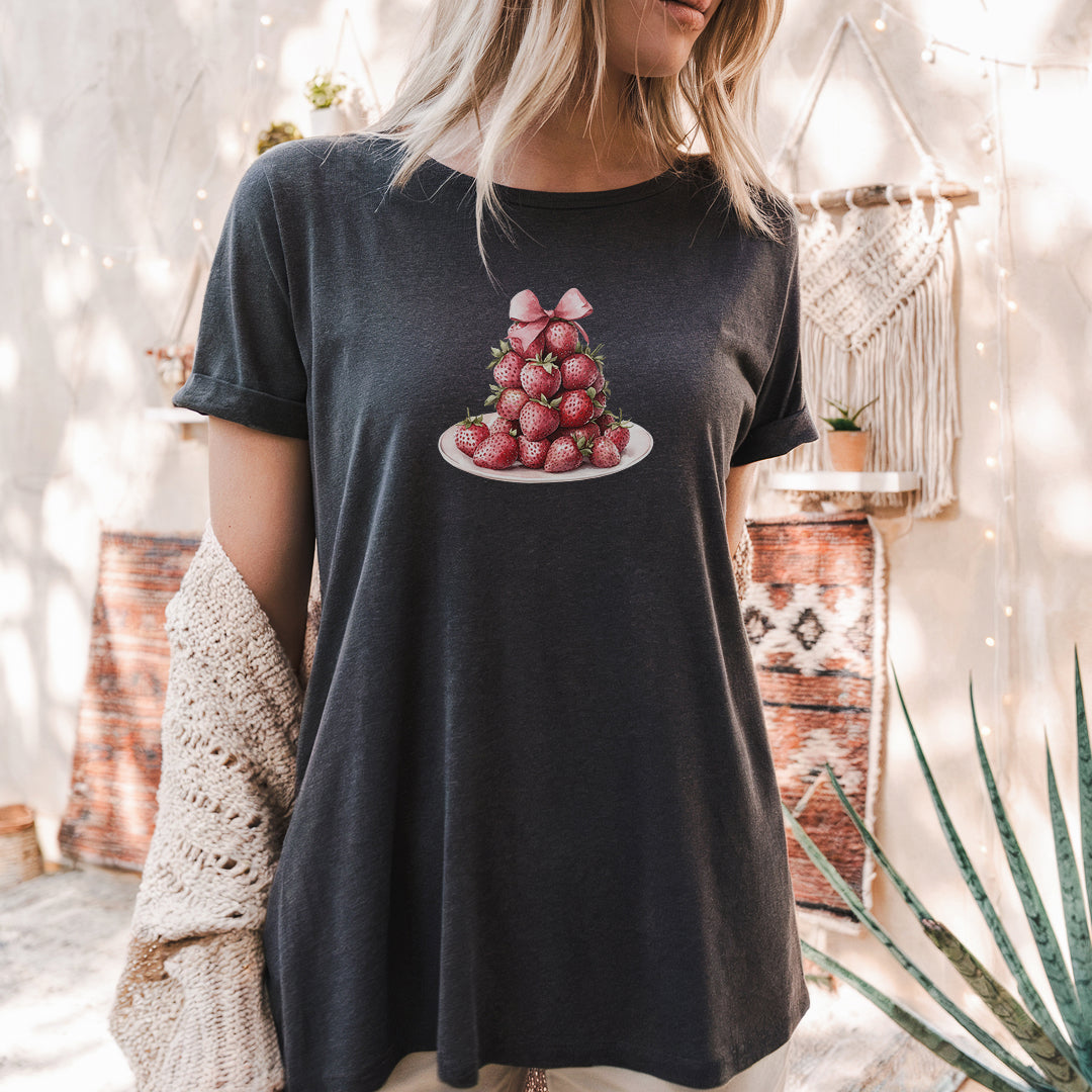 a woman wearing a t - shirt with strawberries on it