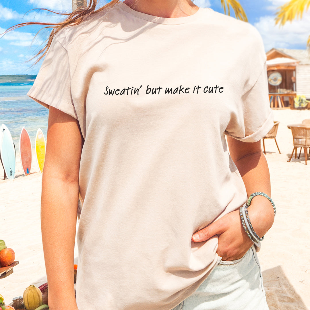 a woman standing on a beach wearing a white shirt