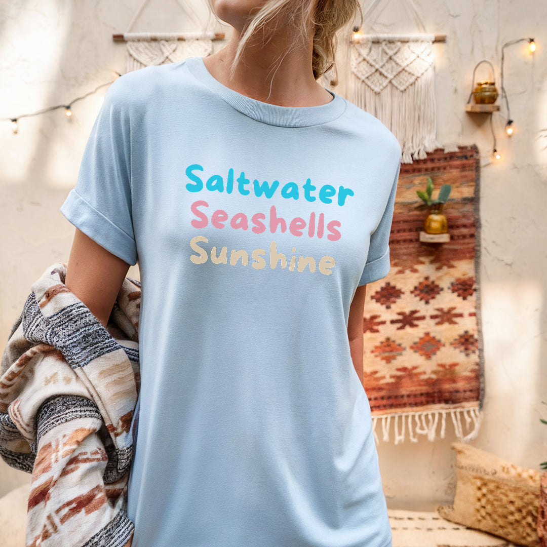 a woman wearing a saltwater seashells sunshine t - shirt