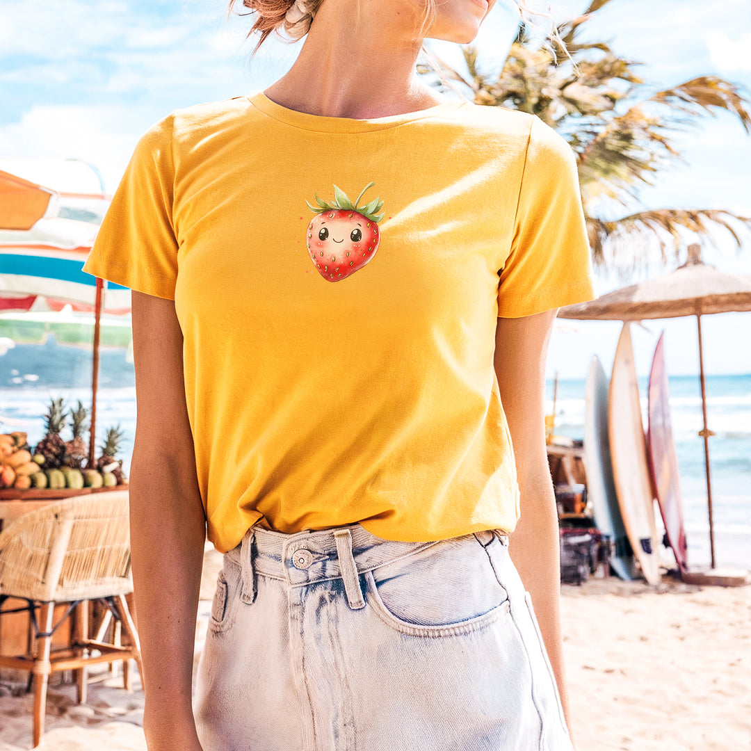 a woman standing on a beach with a strawberries t - shirt on