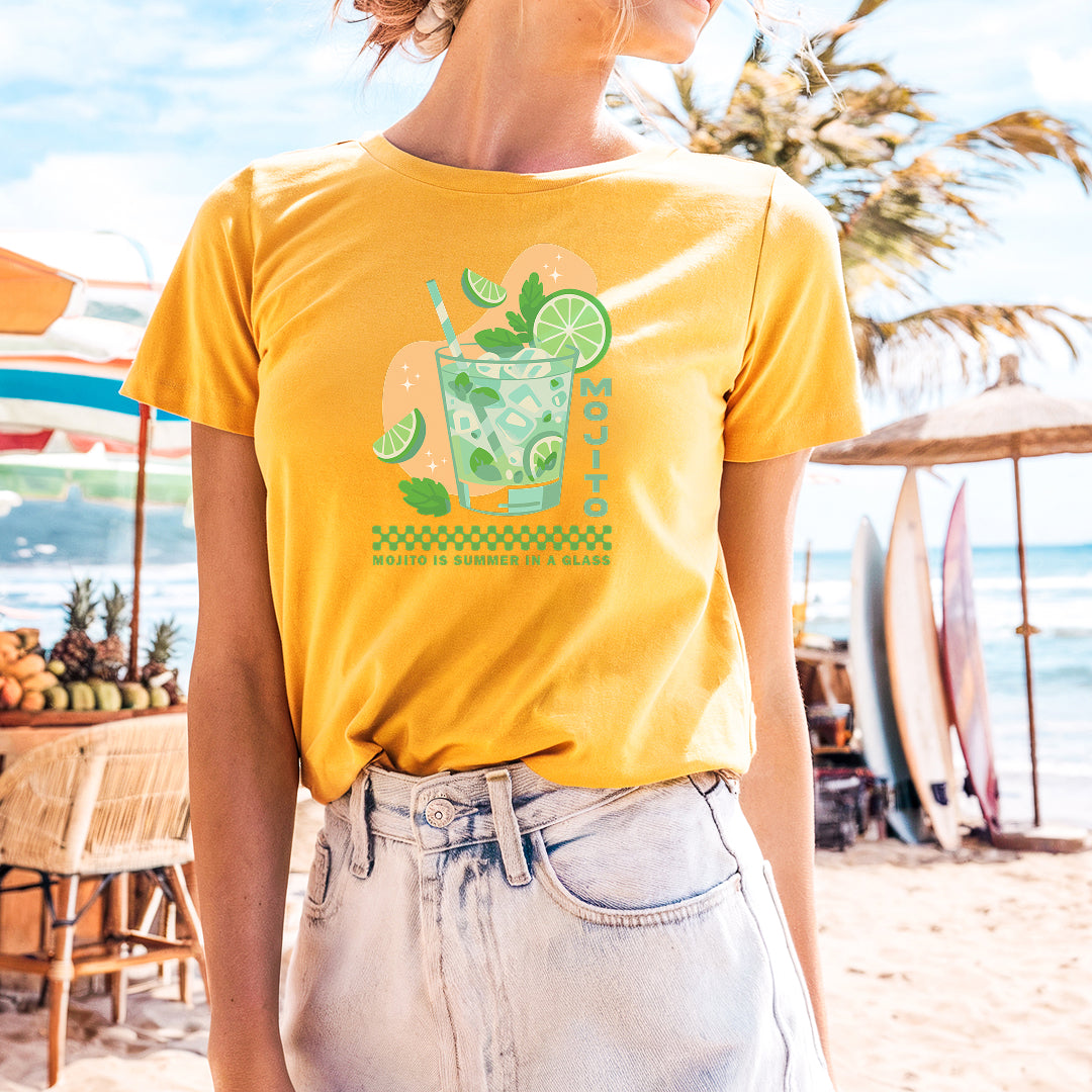 a woman standing on a beach wearing a yellow shirt
