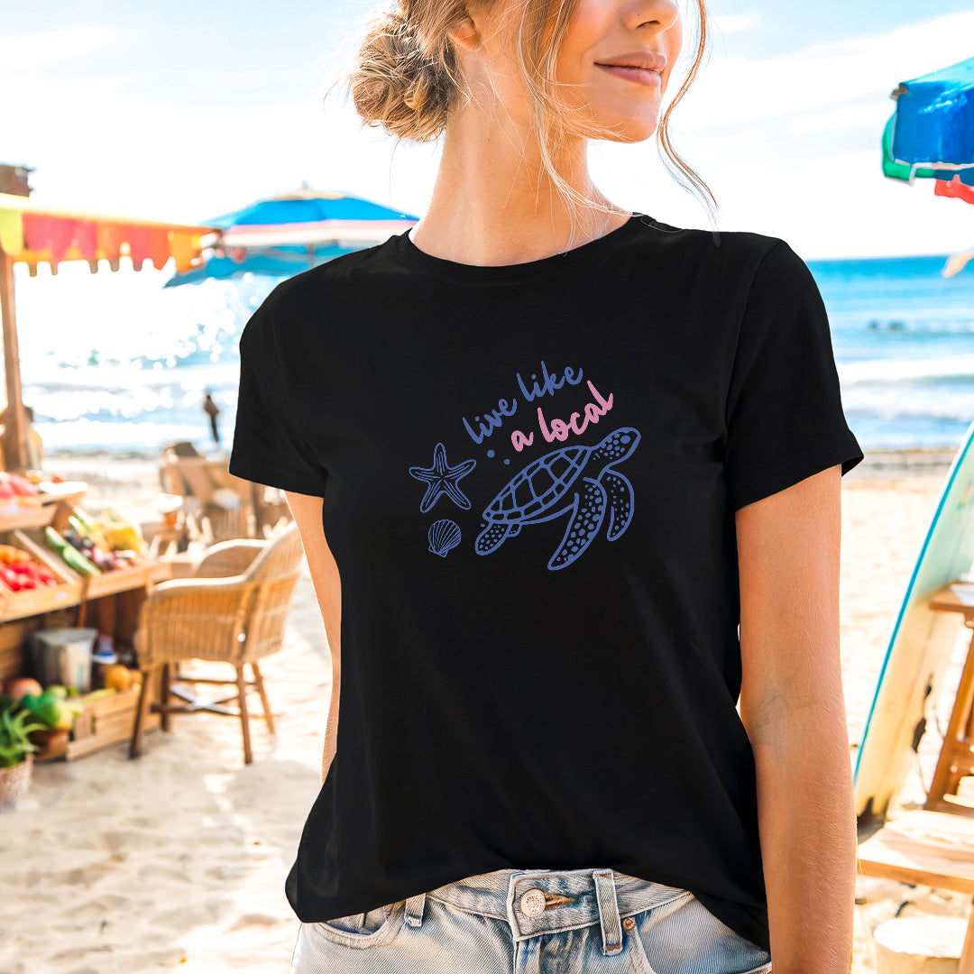 a woman standing on a beach wearing a black shirt