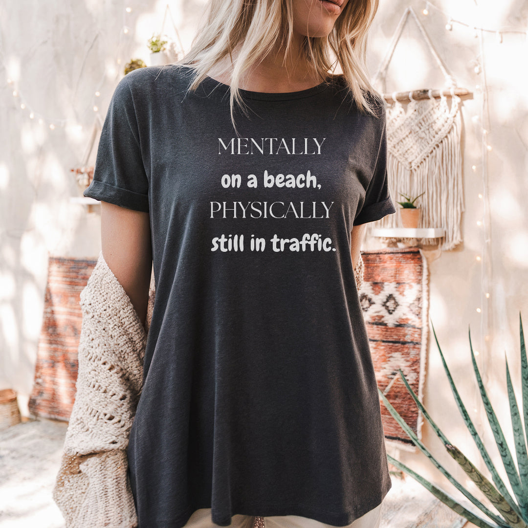 a woman wearing a t - shirt that says mentally on a beach, physically still