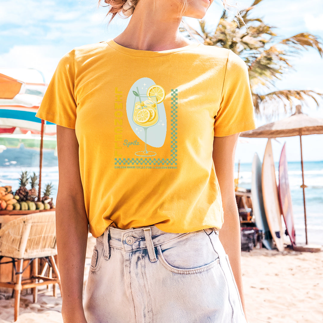 a woman standing on a beach wearing a yellow shirt