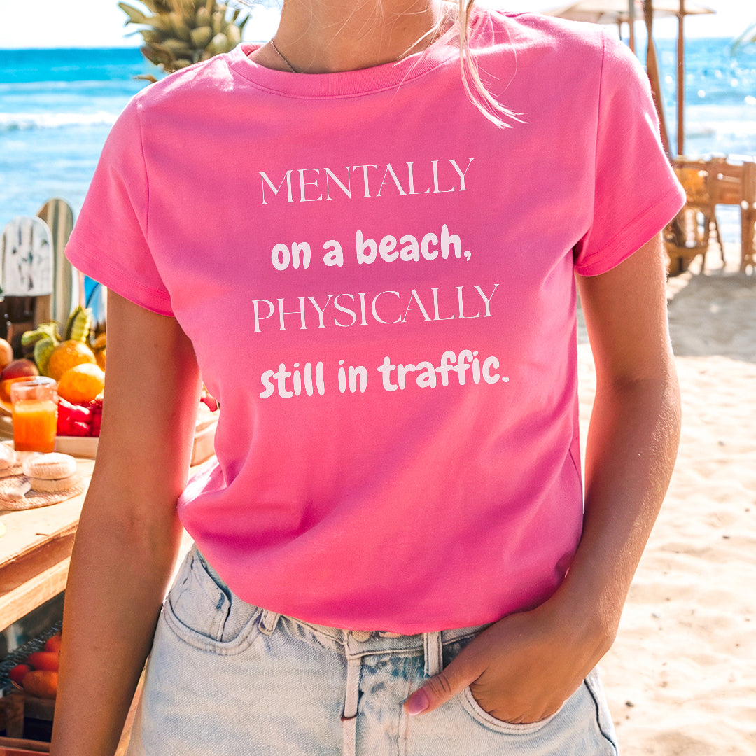 a woman wearing a pink shirt that says mentally on a beach physically still in traffic