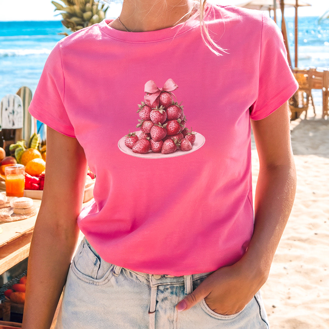 a woman wearing a pink shirt with strawberries on it