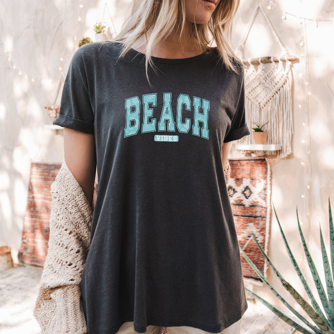 a woman standing in front of a wall wearing a black beach shirt