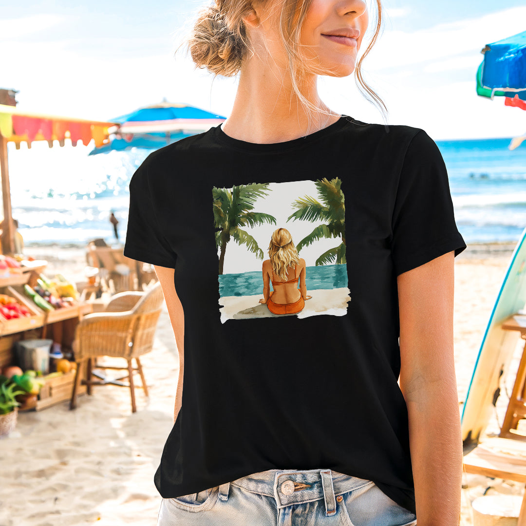 a woman standing on a beach wearing a t - shirt with a picture of a