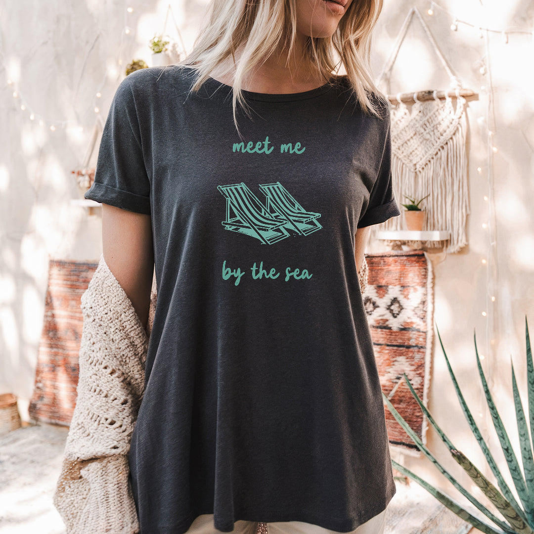 a woman wearing a t - shirt that says meet me by the tea