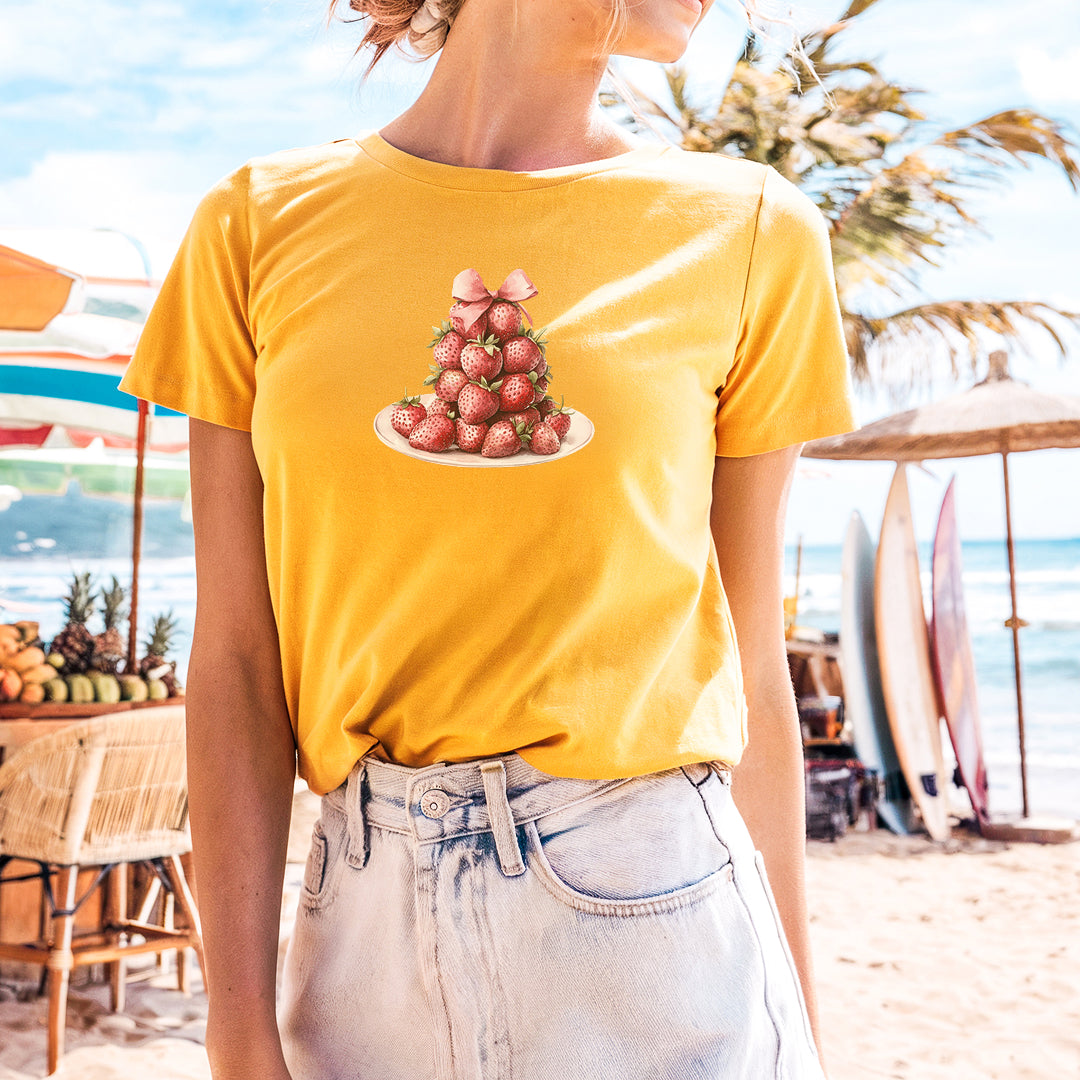 a woman standing on a beach wearing a yellow shirt