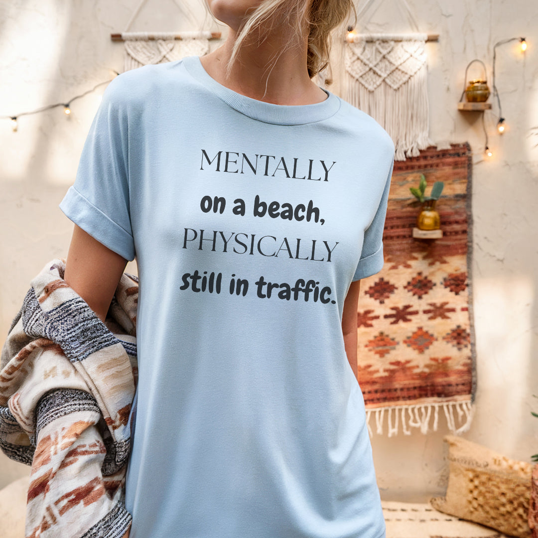 a woman wearing a t - shirt that says mentally on a beach, physically still