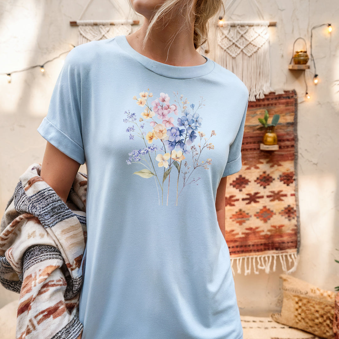 a woman wearing a light blue t - shirt with flowers on it
