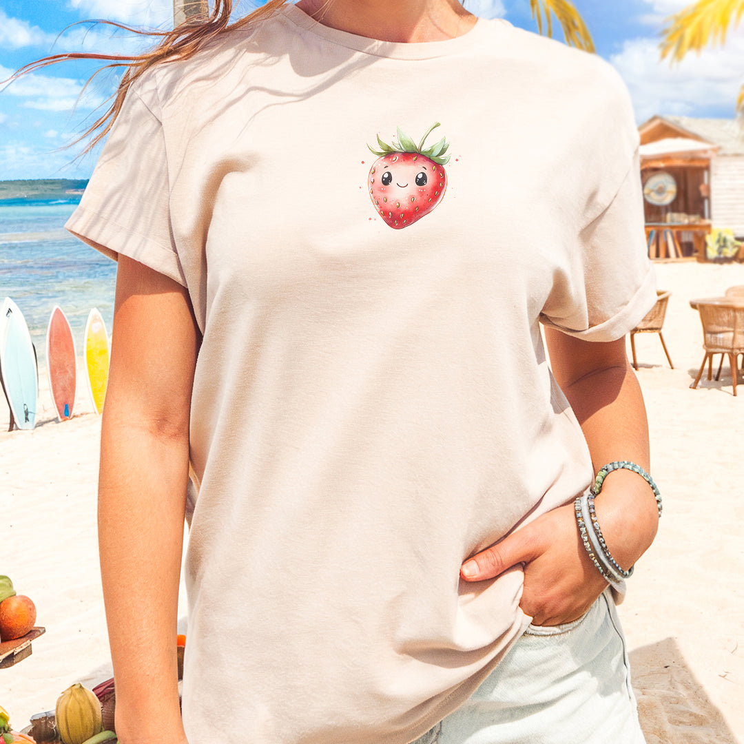 a woman standing on a beach with a strawberries t - shirt on