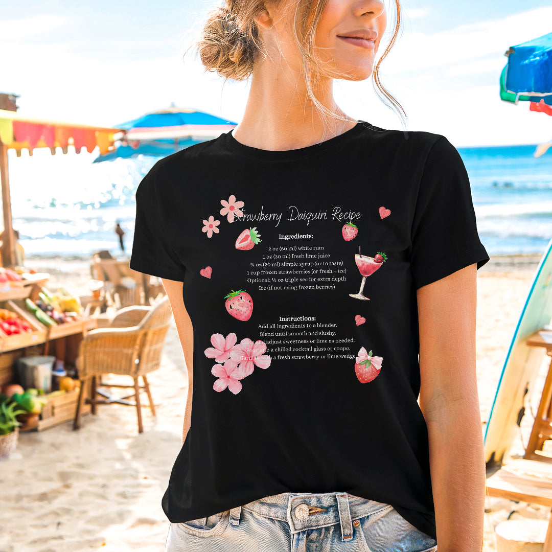 a woman standing on a beach wearing a black shirt