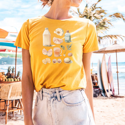a woman standing on a beach wearing a yellow shirt