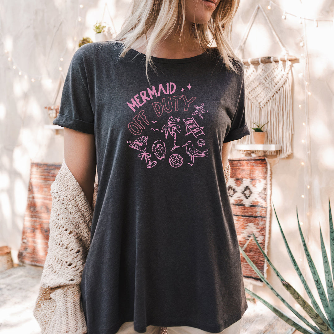 a woman wearing a black shirt that says mermaid on it
