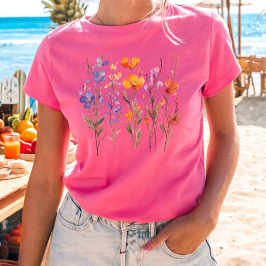 a woman wearing a pink shirt with flowers on it
