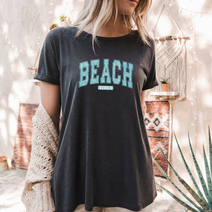 a woman standing in front of a wall wearing a black beach shirt
